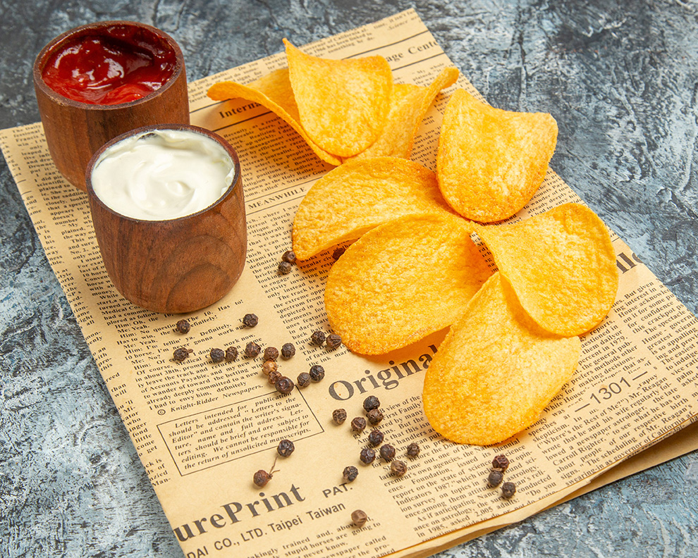 side-view-delicious-homemade-chips-pepper-bowl-mayonnaise-ketchup-newspaper-gray-table
